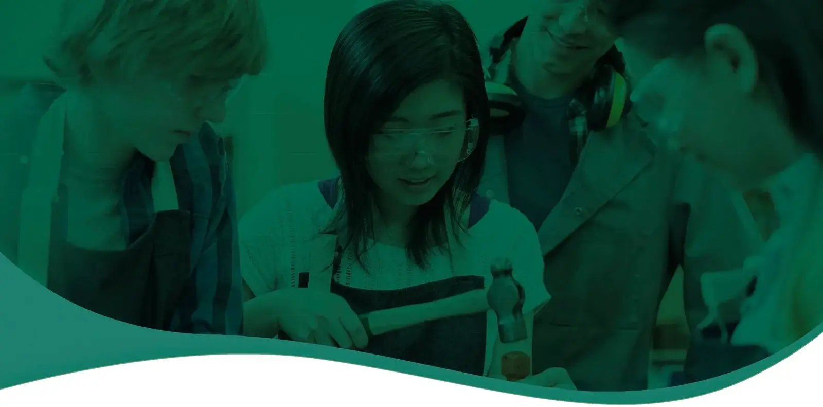 Students gathered around a workbench watching a girl hammer a piece of wood, with a green overlay