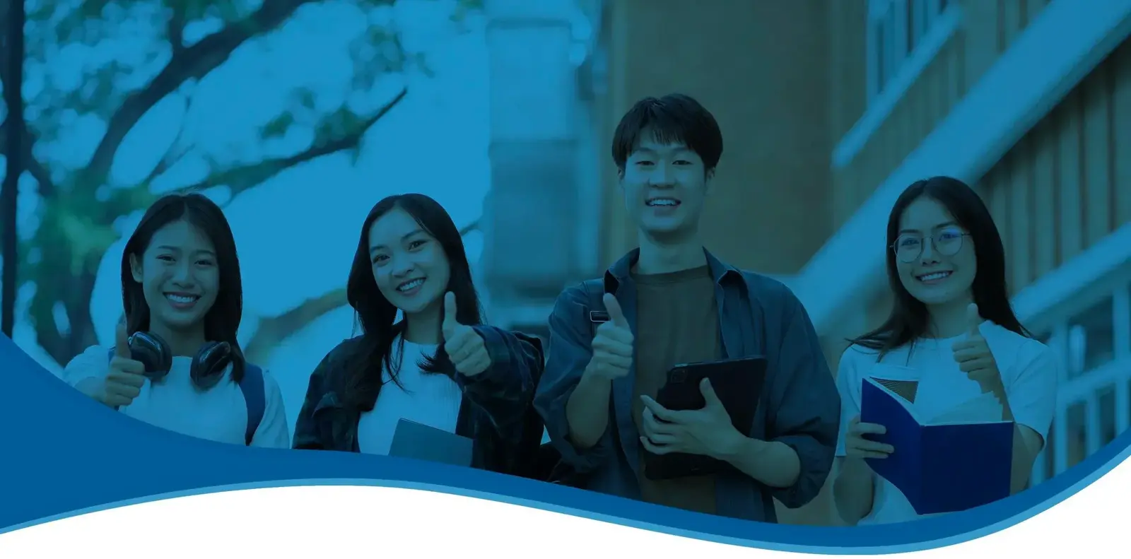 Four smiling students holding books and tablets give thumbs-up outside a campus building, under a blue overlay