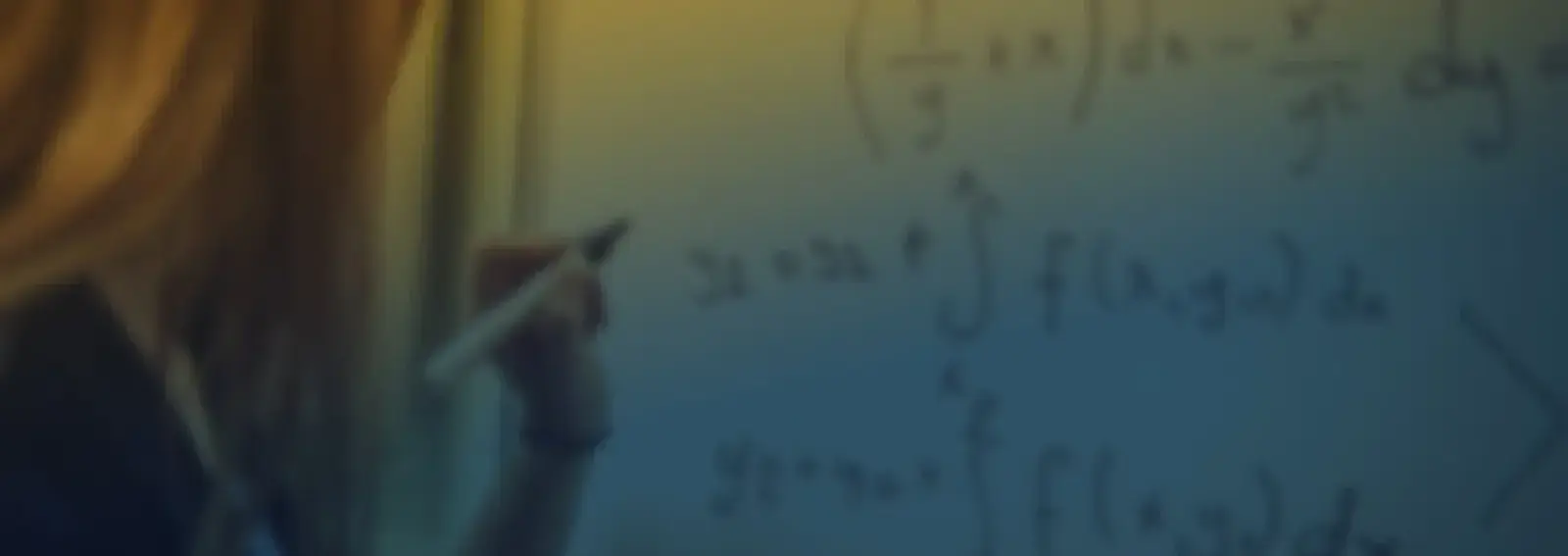 A student writing calculus equations with integrals on a whiteboard