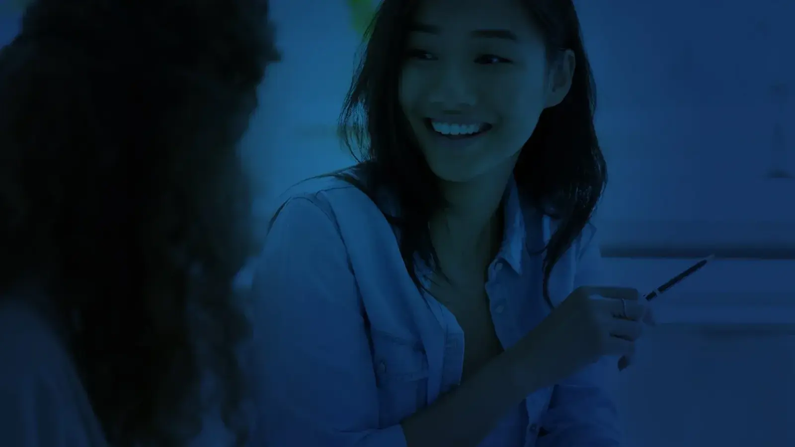 A student smiling while working through practice questions with an Elite Prep tutor.